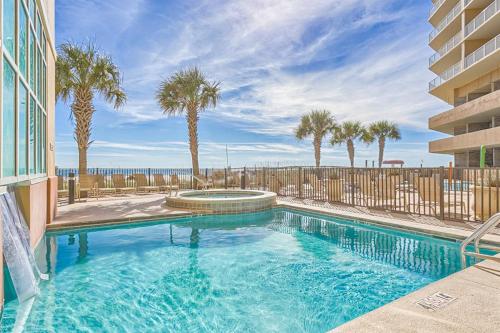 a swimming pool with palm trees and a building at Seawind 1804 in Gulf Shores