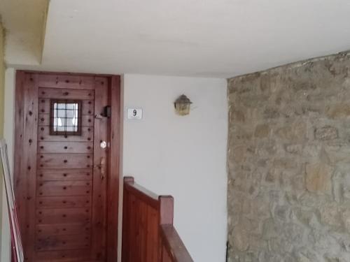 a hallway with a wooden door and a stone wall at Pila Petit Coin Gerdaz Les Fleurs SKI & MTB in Cerise