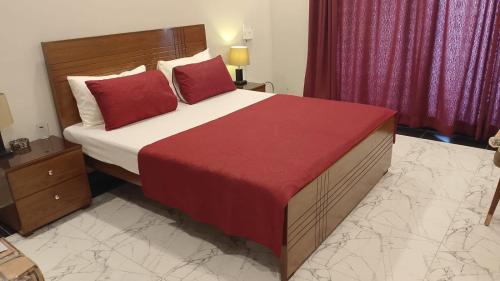 una camera da letto con un letto grande con cuscini rossi di Cozy apartment, luxury amenities! a Rawalpindi