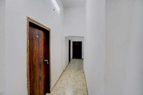 an empty corridor with a wooden door and a room at SPOT ON Manjuvilla in Varanasi