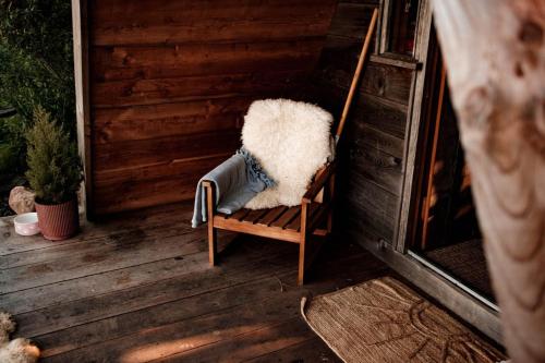 a chair sitting on a porch with a blanket at Pattys Barn Holiday Cottages, Cabins and Venue Hire in Cockerham
