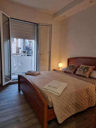 a bedroom with a large bed and a large window at La Trinacria casa vacanze in Bronte
