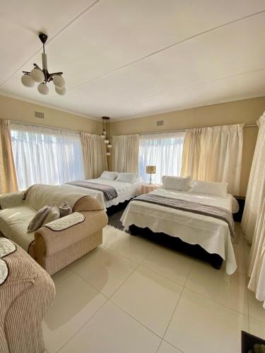 a large room with two beds and a couch at Meadway on the parks in Benoni