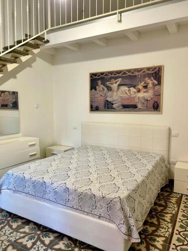 a bedroom with a bed and a painting on the wall at Li Cafari in Aradeo