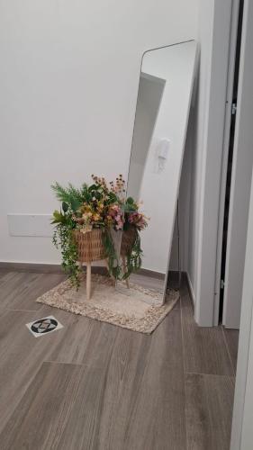 a flower arrangement on a table in front of a mirror at La Trinacria casa vacanze in Bronte
