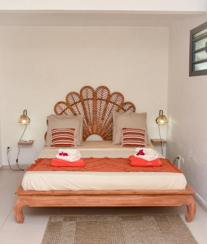 a bedroom with a large bed with a wooden headboard at Lisalyne in Le Moule