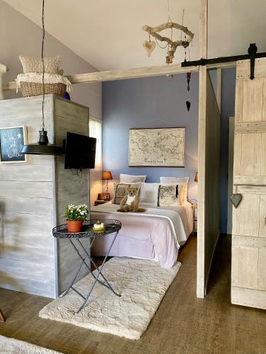 une chambre avec un lit et une table avec une télévision dans l'établissement Le Studio de Sosso, à Aniane