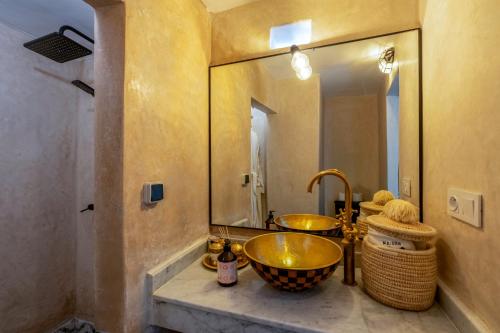 a bathroom with a gold sink and a mirror at Maison H Kasbah in Marrakech
