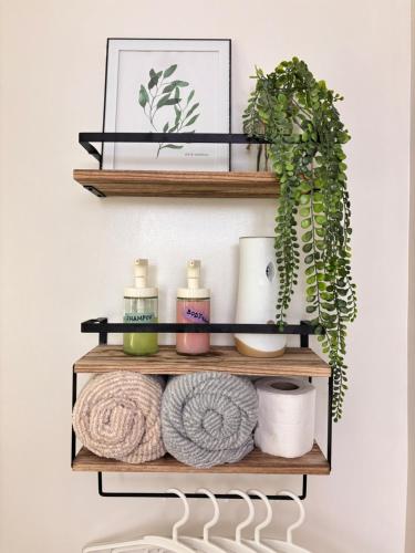 a shelf with towels and plants on it at Casa Lyra Staycation Trees Residences in Manila