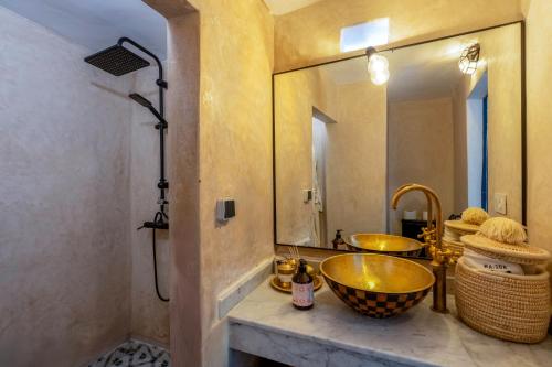 a bathroom with a gold sink and a mirror at Maison H Kasbah in Marrakech