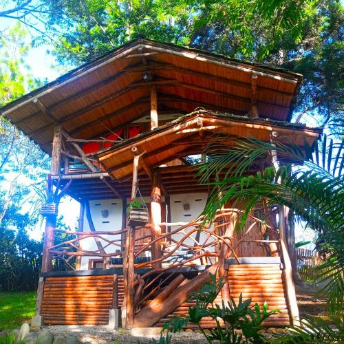 a tree house with a balcony in a garden at Hotel La Casa de Francois in San Agustín