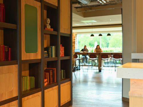 a library with bookshelves and a table in the background at B&B HOTEL Warrington in Warrington