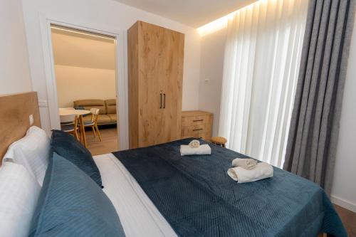 a bedroom with a bed with two towels on it at Villa 3E Boge in Bogë