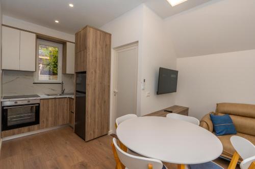 a kitchen and a living room with a table and chairs at Villa 3E Boge in Bogë
