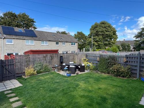 a small backyard with a fence and a lawn at Edinburgh Home from Home in EDI