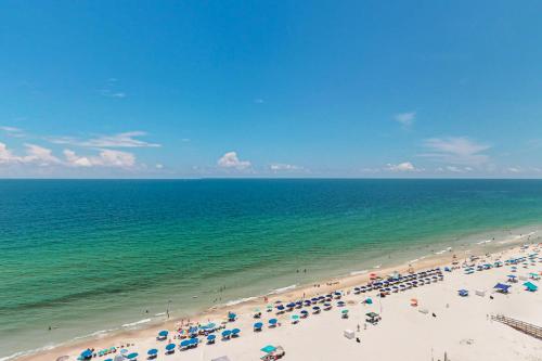 a beach with a lot of umbrellas and the ocean at Phoenix I 1142 in Orange Beach