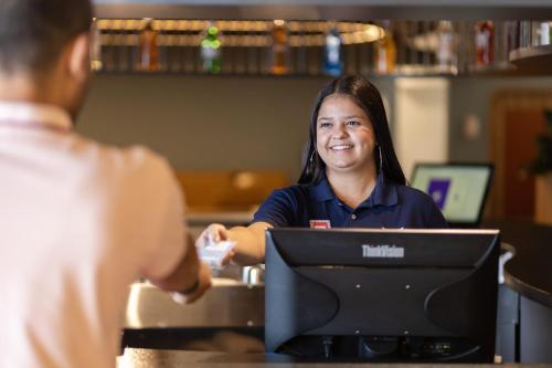 a woman sitting at a desk in front of a computer at ibis Styles Fortaleza Shopping Giga Mall in Fortaleza