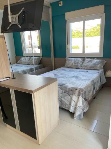 Cette chambre comprend un lit et un bureau. dans l'établissement JK prox Regina e Feevale com AC e espaço Home Office, à Novo Hamburgo