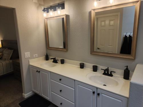 a bathroom with two sinks and a mirror at Paradise home with king bed & room for the family in Lake Havasu City