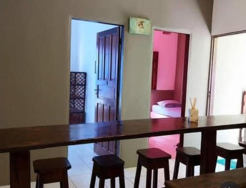 a dining room with a table and some stools at COCOPACKERS Hostel in Cayru