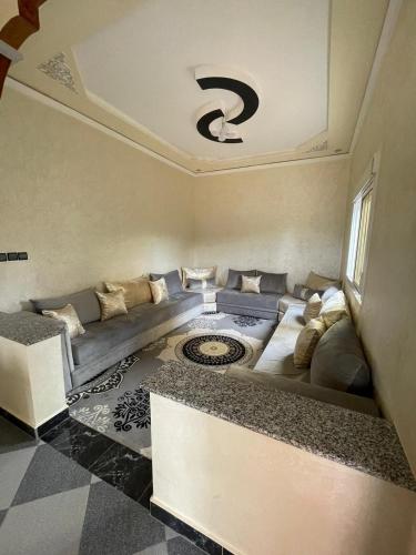 ein Wohnzimmer mit einer Couch und einem Fenster in der Unterkunft ighrem laalam in Rhorm el Alem