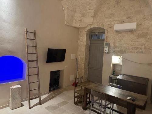 a room with a table and a tv and a ladder at interior jacuzzi APT in Ostuni