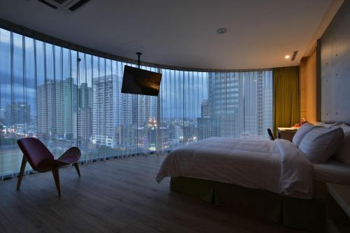 a hotel room with a bed and a view of a city at Hotel R14 in Kaohsiung