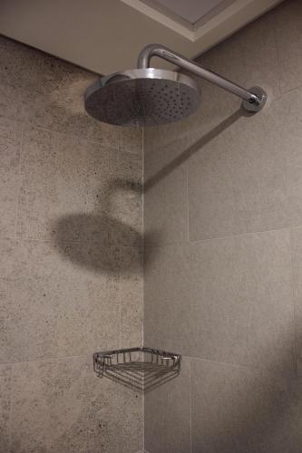 a shower with a glass door with a shower head at Velora Stays Cozy Luxury Apartment in Reem Island in Abu Dhabi