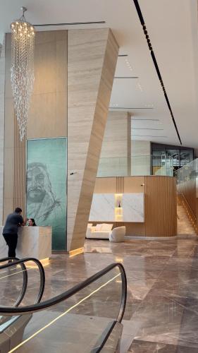 a person standing at a counter in a lobby at Velora Stays Cozy Luxury Apartment in Reem Island in Abu Dhabi