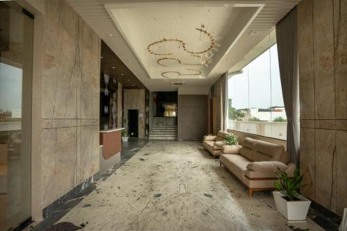 a lobby with couches and a staircase in a building at Hotel La Arriba in Ahmedabad