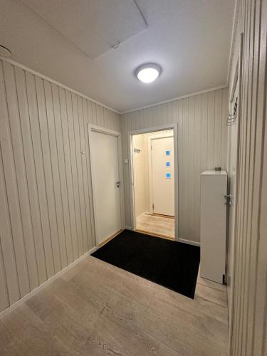 an empty room with a refrigerator and a hallway at Cozy apartment in Tromsø