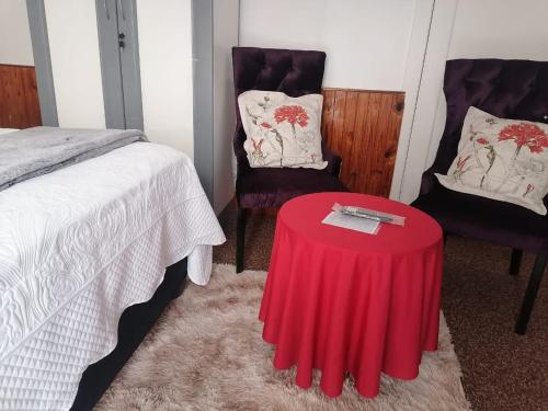 a bedroom with a red table and two chairs at Meadway Cosy retreat for 2 in Benoni