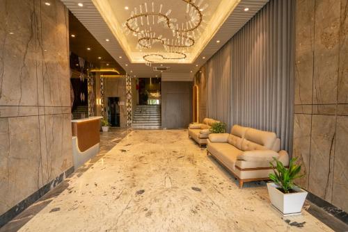 a lobby with couches and a chandelier at Hotel La Arriba in Ahmedabad