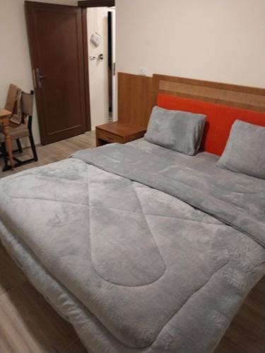 Una cama grande en una habitación con en Fog Mountain Hotel Rooms & sauna, en Jaḩrāʼ