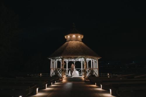 a bride and groom standing in a gazebo at night at The Gailes Hotel & Spa in Irvine