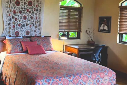 a bedroom with a bed and a desk and windows at Luxury In The Jungle in Barú