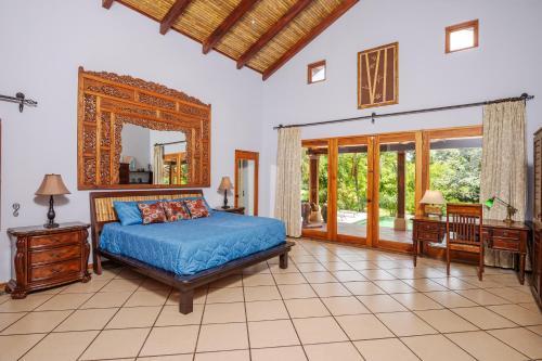a bedroom with a bed and a mirror at Hacienda Pinilla Vacation Rentals in Tamarindo