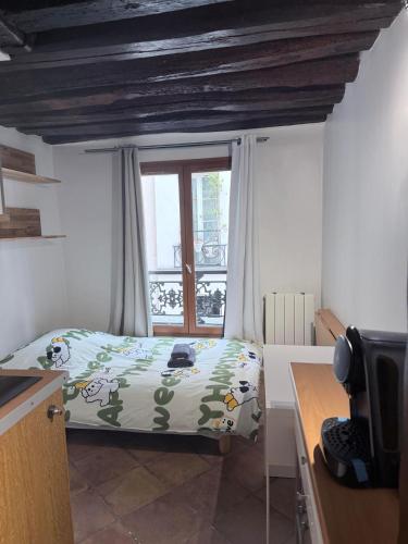 a small bedroom with a bed and a window at Elegant Studio near Pompidou Center in Paris