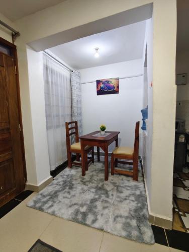 jadalnia ze stołem i dwoma krzesłami w obiekcie Tranquil 2 homes w mieście Nanyuki