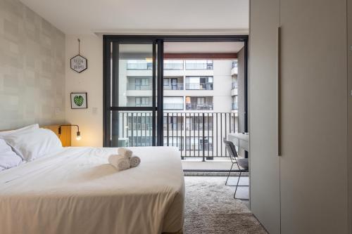 a bedroom with a white bed and a balcony at 360 Vila Mariana in Sao Paulo