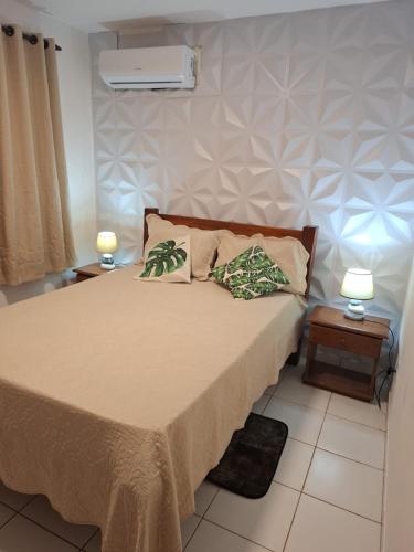 a bedroom with a bed with two pillows on it at Condomio Coqueiros Residence in Salvador