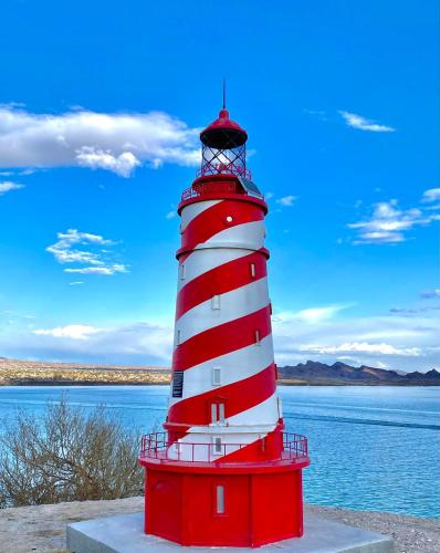 a red and white lighthouse next to a body of water at Paradise home with king bed & room for the family in Lake Havasu City