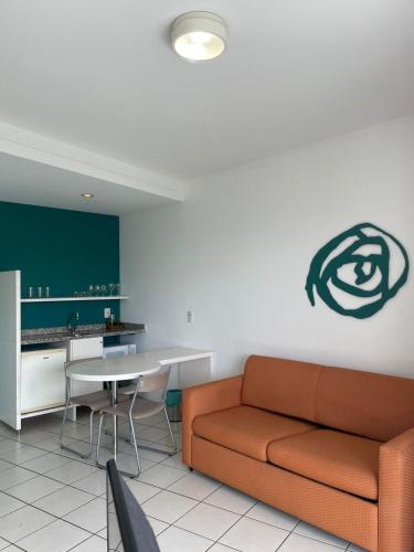 a living room with a couch and a table at Praia do Canto Apart Hotel - Vista para o Mar 102A in Vitória