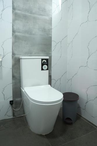 a bathroom with a white toilet and a trash can at Staysia Guest in Kandy
