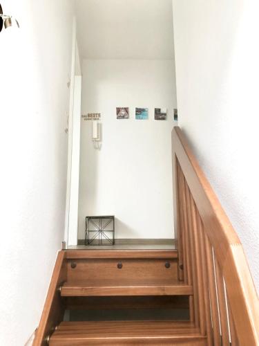 a staircase in a house with a wooden stair case at Moderne Fachwerk-Wohnung im Herzen von Herborn in Herborn