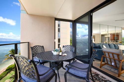 a table and chairs on a balcony with the ocean at Mahana by KBM Resorts in Kaanapali