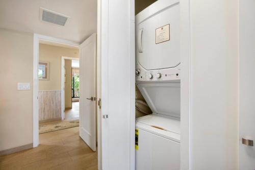 a kitchen with an open washer and dryer at Mahana by KBM Resorts in Kaanapali