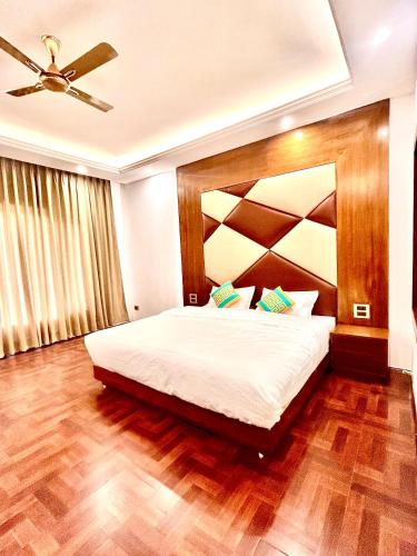 a bedroom with a large bed with a wooden headboard at The Host Ladakh in Leh