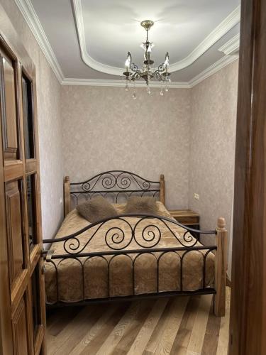 a bedroom with a bed and a chandelier at Remember Me B&B in Dilijan