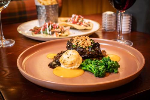 two plates of food on a table with broccoli at The Loans Inn in Troon